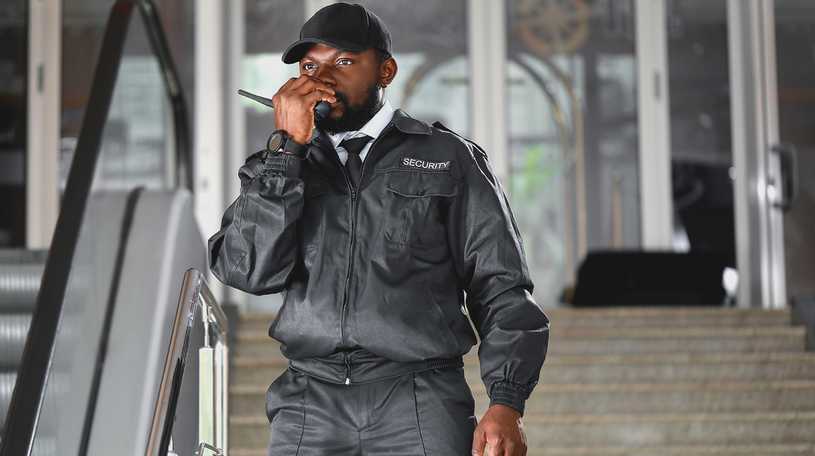 Security guard making call on walkie-talkie