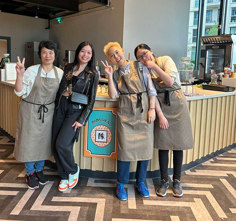 Four smiling people in front of Mama Chen's pop-up shop