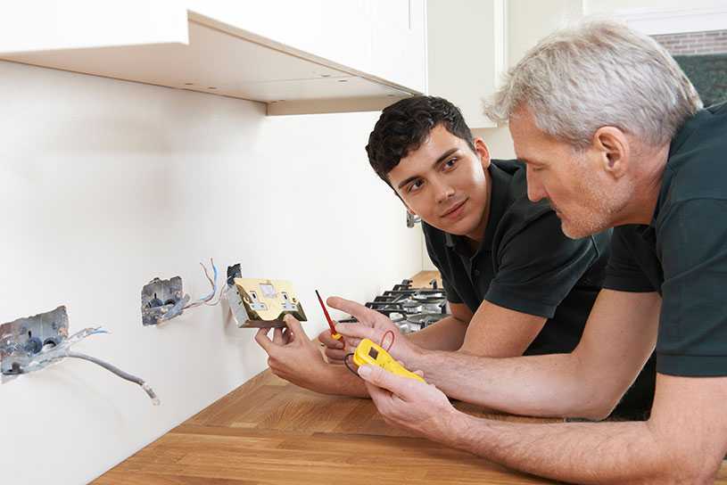 A small business owner with his electrician apprentice