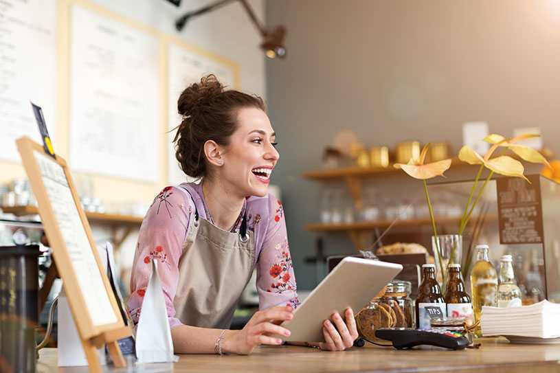 Small business owner in coffee shop with tablet