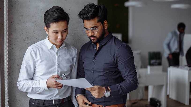 Two male business analysts looking at a report