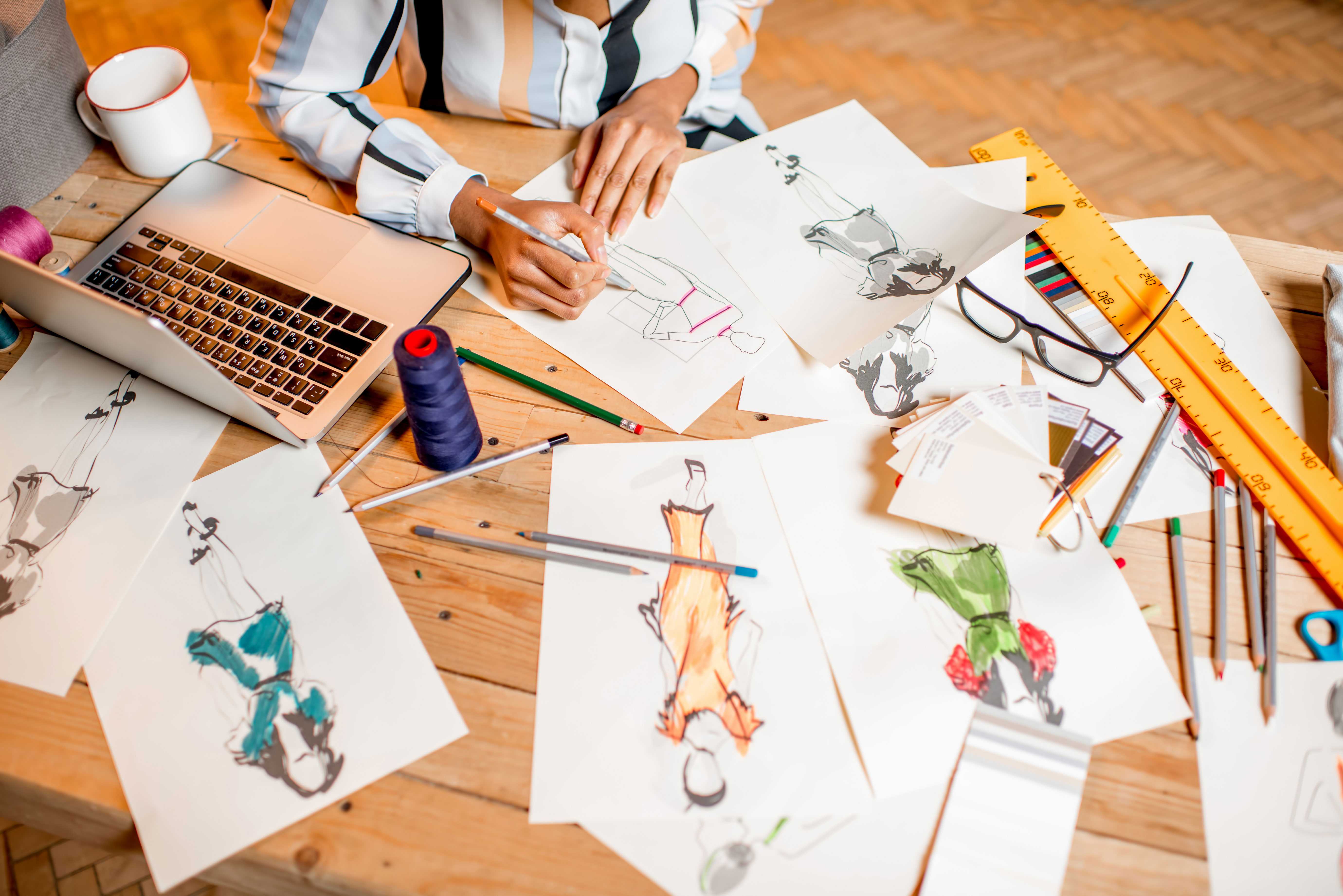 Fashion designer working with clothes and drawings