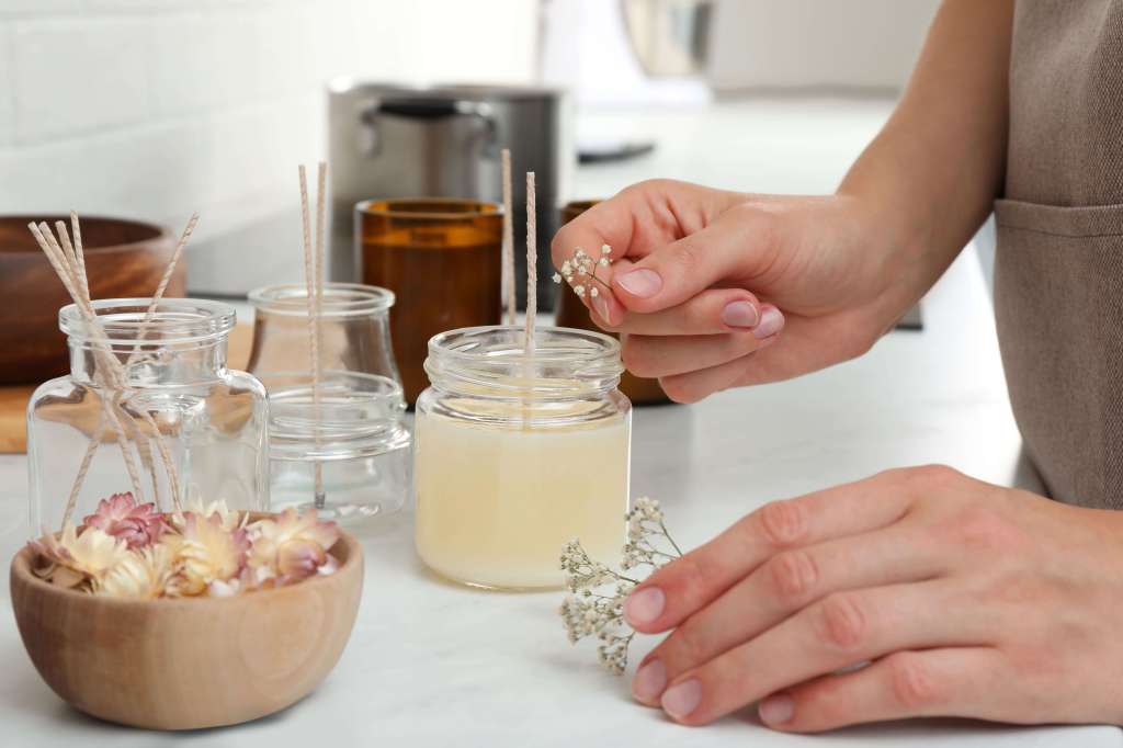 Woman decorating candles with flowers