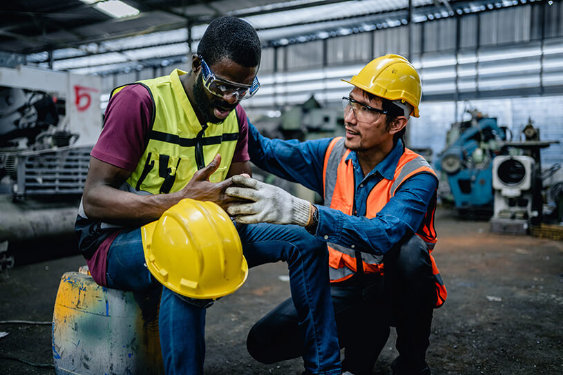 An injured worker with another worker wearing a hard hat
