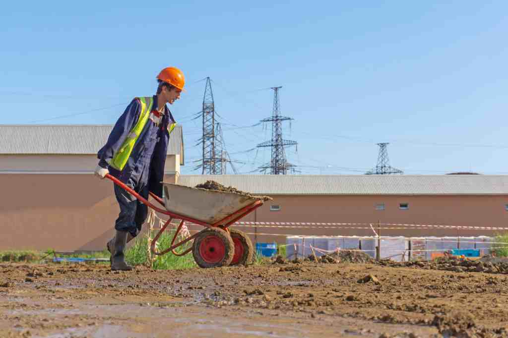 Groundworker using wheelbarrow