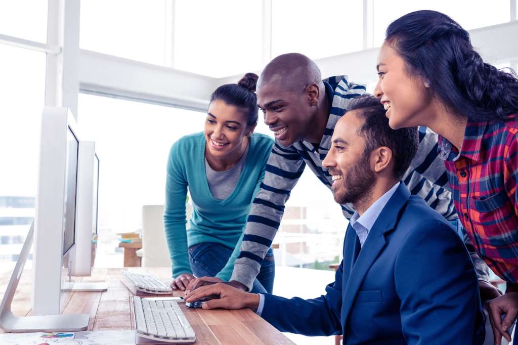 Happy team crowded around computer
