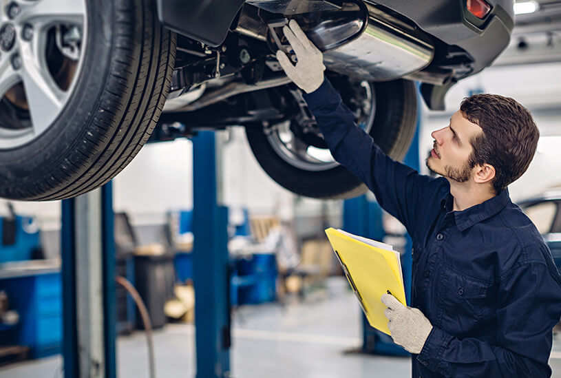 Engineer completing MOT test for business vehicle