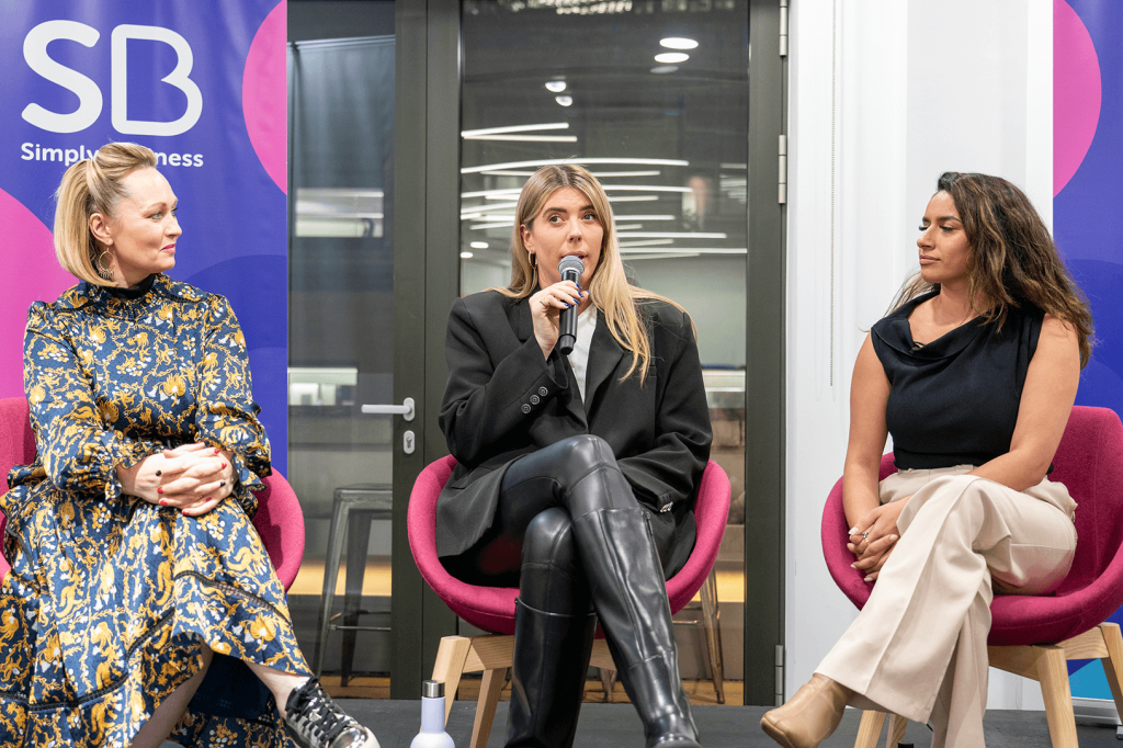 Three women business owners speaking on stage at panel event