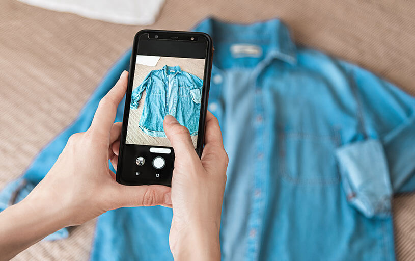 Seller taking a photo of a shirt on phone