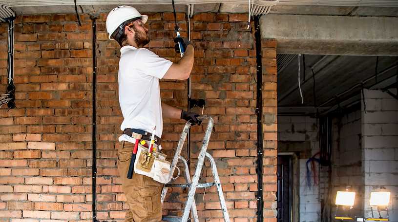 Electrician installing wiring in a residental house