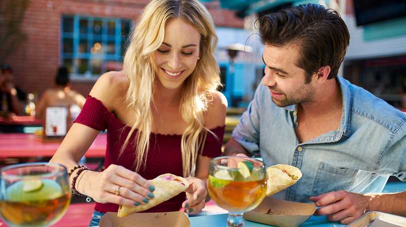 Man and woman enjoying food at an outdoor restaurant