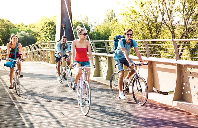 Happy tourists cycling across a bridge