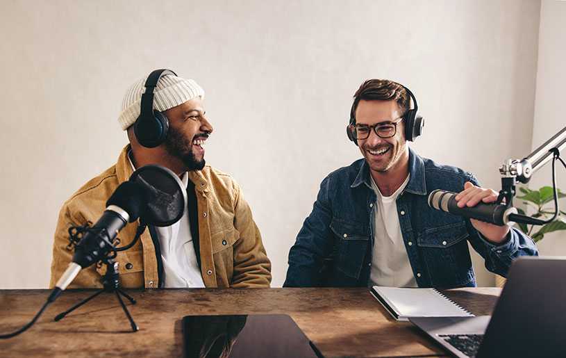 Two smiling men recording radio advert