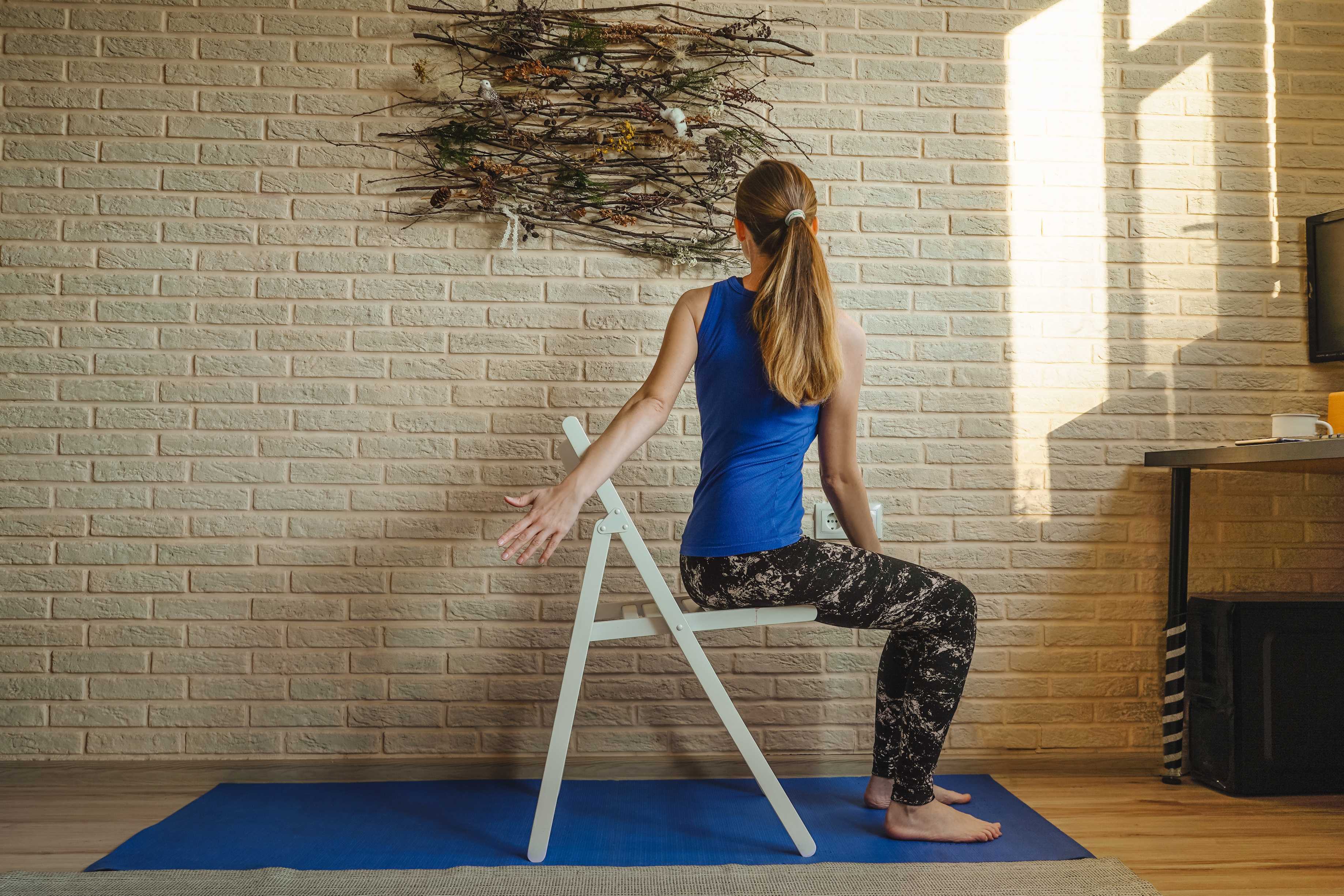 woman doing chair yoga at home