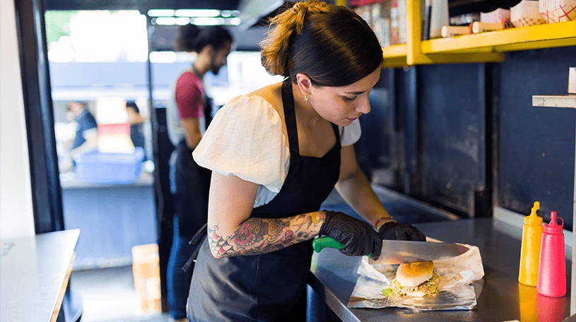 Chef cutting a sandwich in a food van