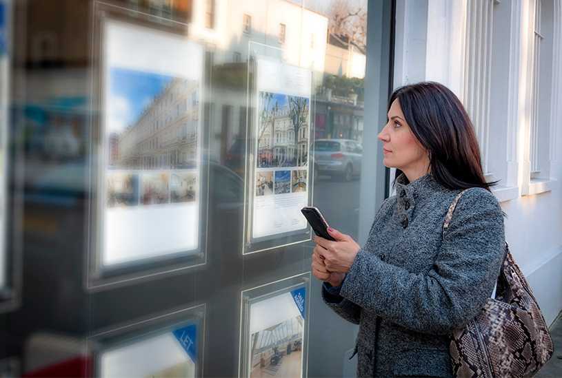 Landlord looking in estate agent's window