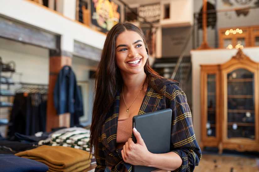 Female business owner smiling in clothes shop