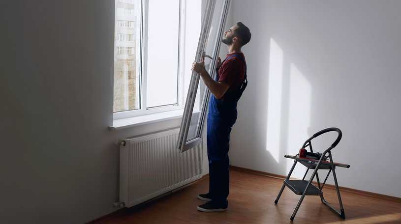 A glazier installing a new window in a flat