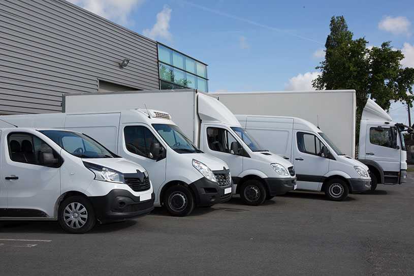 Commercial vans lined up in parking spaces at warehouse