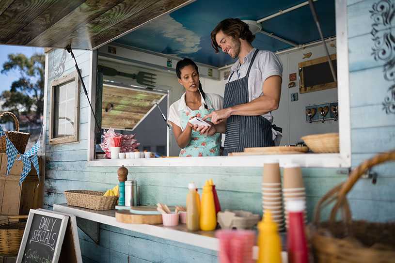 Two street food business owners checking orders