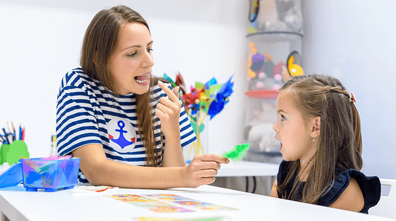 A speech therapist helping a child speak