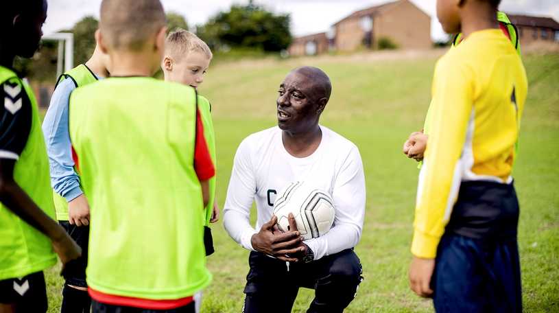 Children‘s football coach giving a team talk