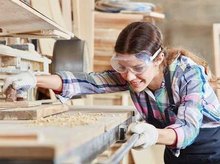 A female carpenter working at a workbench