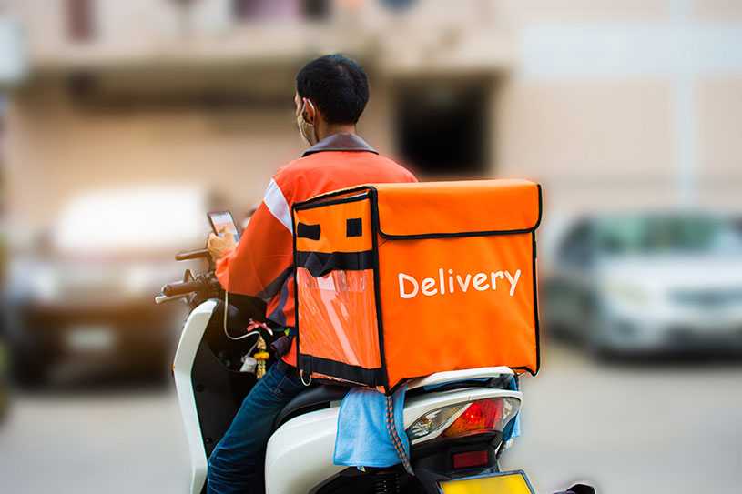 A self-employed food delivery driver on their bike