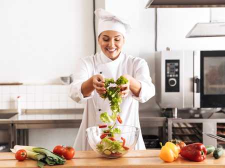 A chef tossing a salad in the kitchen