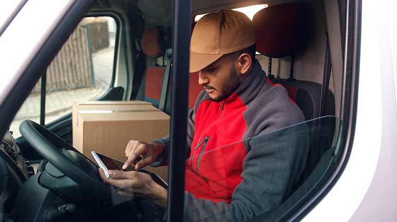 Delivery driver using tablet in his van