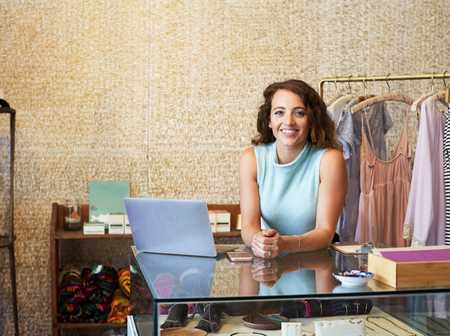 A young entrepreneur sat at the counter of their fashion boutique