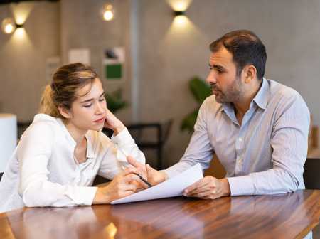 Two people discussing paperwork in an office