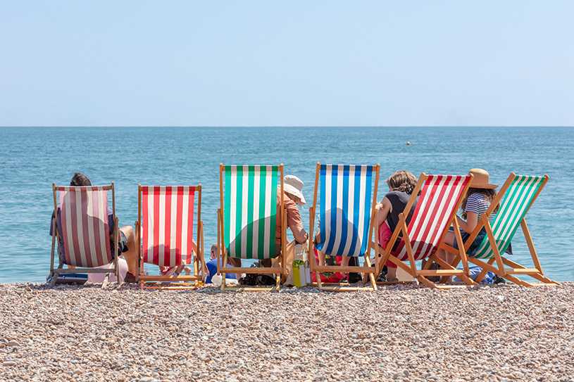 Holiday deckchairs lined up on a pebble beach