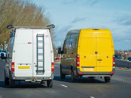 Two business vans driving on a UK road