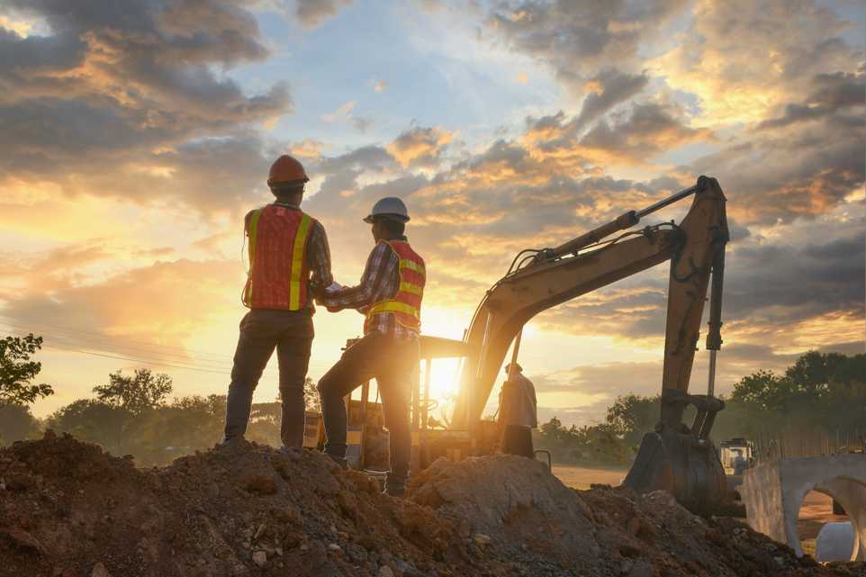 Workers on a construction site with sunset