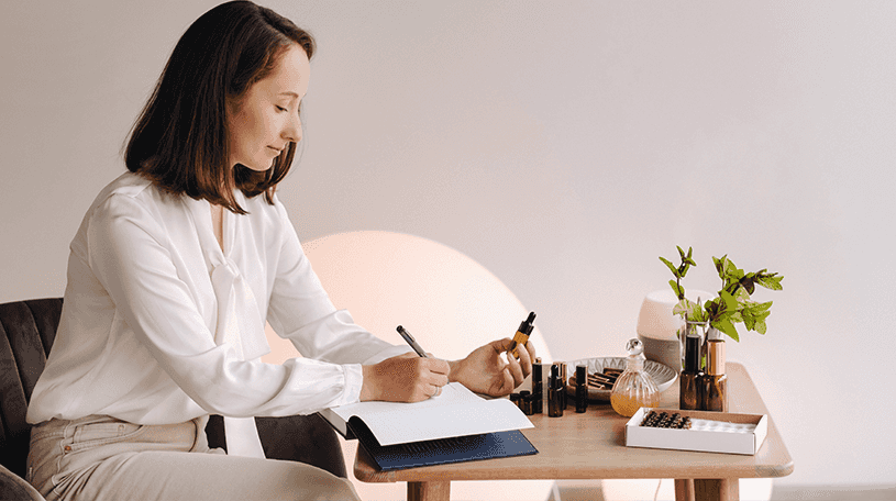 Aromatherapist examining bottle and writing details