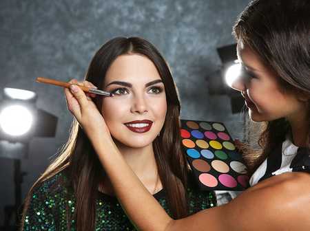 Makeup artists applying makeup to a model