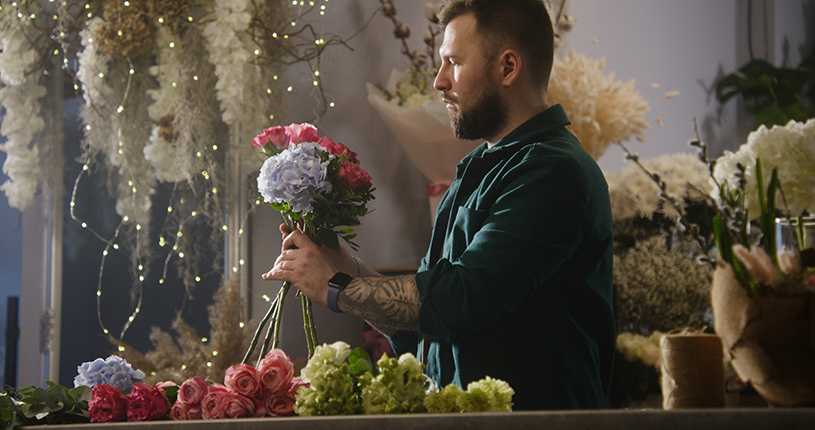 Professional florist creates bouquet in shop
