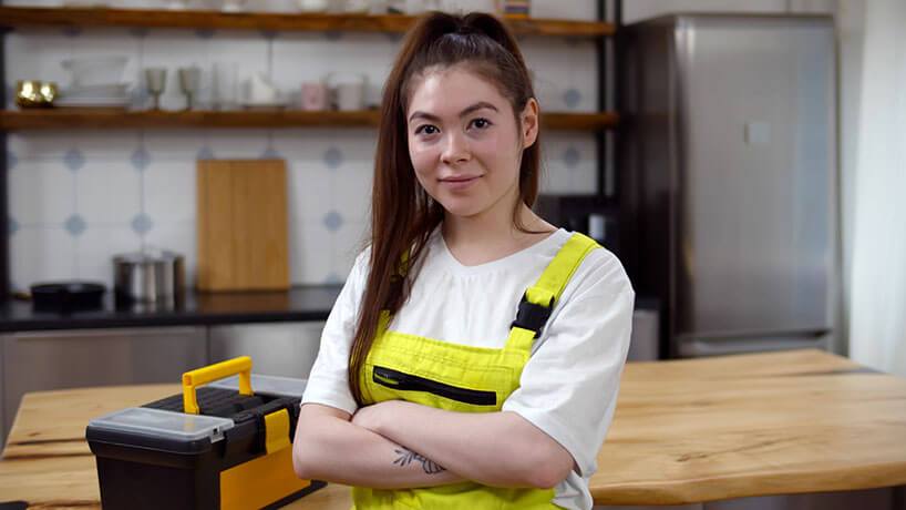 A female business owner stands with her toolbox