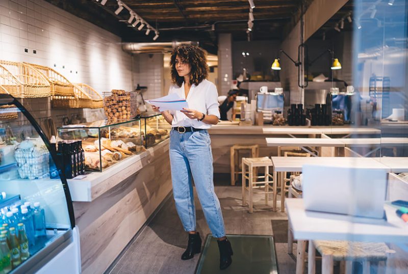 Cafe owner looking at a late payment letter