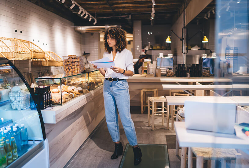 Cafe owner looking at a late payment letter