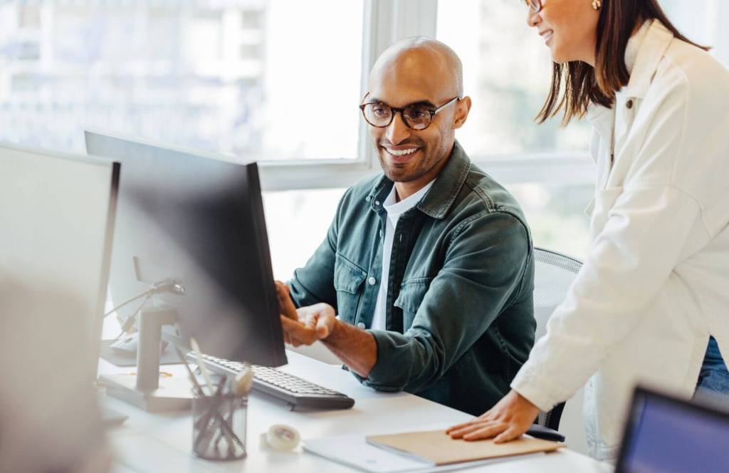 Coworkers looking at a laptop