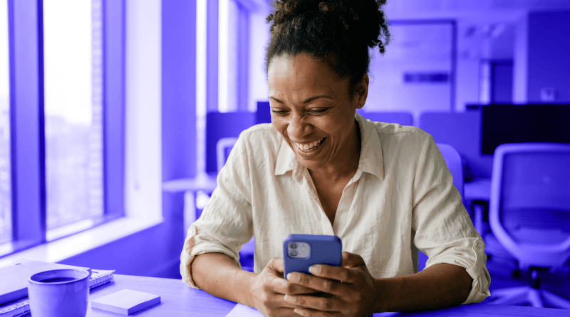A small business owner laughs at her phone