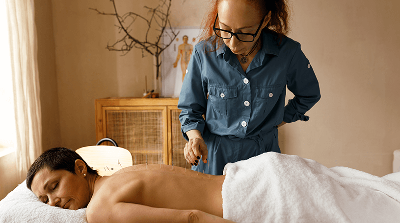 Acupuncturist working on client