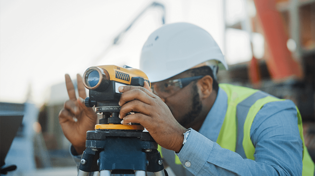 Surveyor using theodolite outside