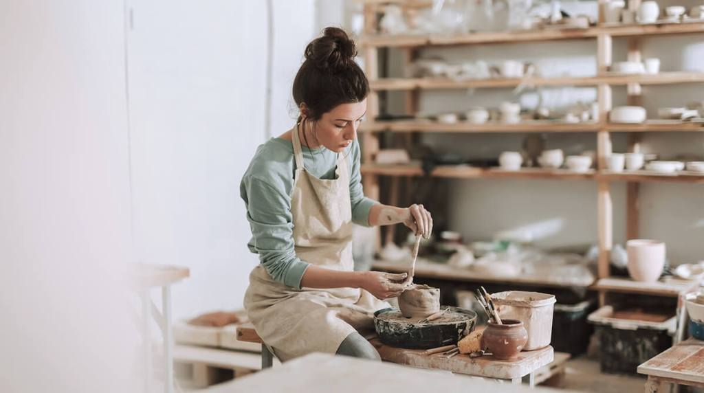 Woman making a pot out of clay