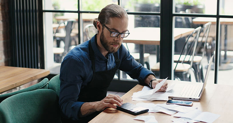 Man sitting in a café doing financial calculations
