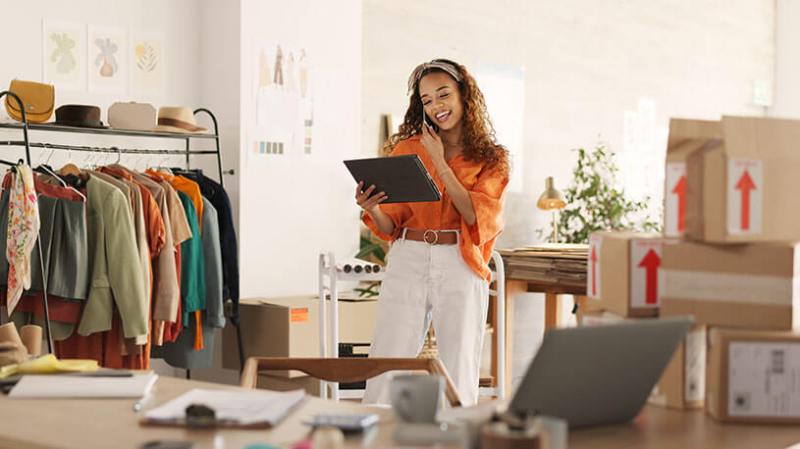 Happy woman with tablet taking sales orders and checking inventory.