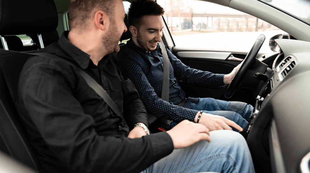 Driving instructor telling learner driver how to use dashboard controls