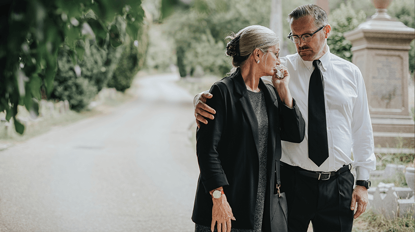 Man consoling a woman at a funeral